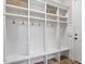Mudroom featuring white cubbies with hooks and bench seating, with tile flooring at 7906 Longleaf Branch Ct, Raleigh, NC 27612