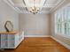Versatile office space featuring hardwood floors, a modern light fixture, and a large window at 7906 Longleaf Branch Ct, Raleigh, NC 27612
