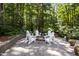 Backyard gathering space features Adirondack chairs around a firepit nestled in a serene setting at 8004 Gabriels Bend Dr, Raleigh, NC 27612