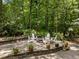 Outdoor patio with a fire pit, surrounded by chairs, flowers and beautiful landscaping at 8004 Gabriels Bend Dr, Raleigh, NC 27612