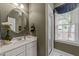 Neutral-toned bathroom with a tiled shower, single vanity, and bright window at 8004 Gabriels Bend Dr, Raleigh, NC 27612