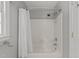 Standard tub and shower combination featuring neutral tile, chrome fixtures, and a shower caddy at 8004 Gabriels Bend Dr, Raleigh, NC 27612