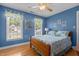 Stylish bedroom with hardwood floors, blue walls, and large windows providing natural light at 8004 Gabriels Bend Dr, Raleigh, NC 27612