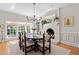 Sunlit dining room features a fireplace, wood floors, and an elegant chandelier for sophisticated meals at 8004 Gabriels Bend Dr, Raleigh, NC 27612