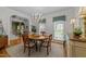 Bright dining room with hardwood floors, a round wood table, and a view into another room at 8004 Gabriels Bend Dr, Raleigh, NC 27612