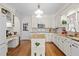 Charming kitchen with white cabinetry, an island, and hardwood floors at 8004 Gabriels Bend Dr, Raleigh, NC 27612