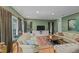 Well-lit living room with multiple windows, hardwood floors, and comfortable seating arrangements at 8004 Gabriels Bend Dr, Raleigh, NC 27612