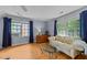 Bright living room with hardwood floors, a floral sofa, and natural light from large windows at 8004 Gabriels Bend Dr, Raleigh, NC 27612