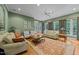 Spacious living room with large windows, comfortable sofas, a ceiling fan, and an area rug at 8004 Gabriels Bend Dr, Raleigh, NC 27612
