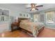 Spacious bedroom with hardwood floors, a ceiling fan, and a large bed with floral bedding at 8004 Gabriels Bend Dr, Raleigh, NC 27612