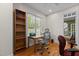 Home office with natural light, hardwood floors, built-in bookcase, and a neutral palette at 8004 Gabriels Bend Dr, Raleigh, NC 27612