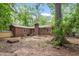 Rear view of a brick home featuring the exterior, chimney, and backyard landscaping in a wooded setting with mature trees at 809 Valerie Dr, Raleigh, NC 27606