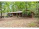 Quaint single-story brick home featuring traditional shutters and a welcoming front porch surrounded by mature trees at 809 Valerie Dr, Raleigh, NC 27606