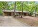 Traditional brick home with attached carport and charming front porch, nestled in a wooded lot with mature trees at 809 Valerie Dr, Raleigh, NC 27606