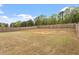 Large backyard with lush green grass, a wood fence, and plenty of trees at 815 Harmony Ranch Ln, Franklinton, NC 27525