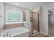 Spa-like bathroom featuring a soaking tub and glass enclosed shower at 815 Harmony Ranch Ln, Franklinton, NC 27525