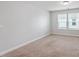 This bedroom offers neutral carpeting, a large window, and white walls at 815 Harmony Ranch Ln, Franklinton, NC 27525