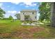 Large, grassy backyard with a garden area, hammock, and mature trees for shade at 947 Weatherby Ln, Creedmoor, NC 27522