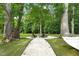 Relaxing backyard with a stone firepit area, hammock, and mature trees providing shade and privacy at 947 Weatherby Ln, Creedmoor, NC 27522