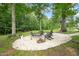 Relaxing backyard gravel fire pit area with mature trees and Adirondack chairs at 947 Weatherby Ln, Creedmoor, NC 27522