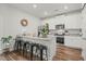 Bright kitchen with white cabinets, granite countertops, stainless steel appliances, and bar stool seating at 947 Weatherby Ln, Creedmoor, NC 27522