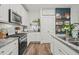 Bright kitchen features stainless steel appliances, granite countertops, and decorative shelving with wood accents at 947 Weatherby Ln, Creedmoor, NC 27522