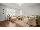 Spacious living room with plush seating, large windows for natural light, and a cozy rug at 947 Weatherby Ln, Creedmoor, NC 27522