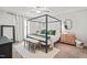 Bright main bedroom suite features a four-poster bed with fresh bedding and a neutral color palette at 947 Weatherby Ln, Creedmoor, NC 27522