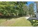 A fenced backyard with a lush lawn and mature trees offers privacy and tranquility at 105 Leacroft Way, Durham, NC 27703