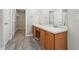 Large bathroom featuring dual sinks, ample counter space, wood cabinets, and a private door to the walk-in closet at 105 Leacroft Way, Durham, NC 27703