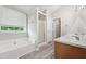 Serene bathroom with dual vanities, soaking tub, separate shower, and a linen closet for ultimate relaxation and convenience at 105 Leacroft Way, Durham, NC 27703
