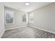 Comfortable bedroom with laminate floors and three bright windows, ready for your personal touch, bringing in natural light at 105 Leacroft Way, Durham, NC 27703