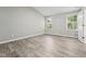Bright bedroom featuring two windows and sleek laminate floors, offering a modern and airy feel for comfort at 105 Leacroft Way, Durham, NC 27703