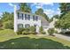 A charming white two-story home with green shutters, a well-kept lawn, and a driveway leading to the garage at 105 Leacroft Way, Durham, NC 27703