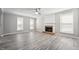 Bright living room with fireplace, neutral walls, wood floors, large windows, and ample natural light at 105 Leacroft Way, Durham, NC 27703