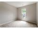 Neutral bedroom featuring carpet flooring and a window overlooking the side yard, providing ample light at 107 Tuftin Dr, Durham, NC 27703