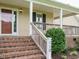 Inviting front porch with brick steps, a wooden railing, and the house number displayed on a post at 110 Westlake Dr, Wendell, NC 27591