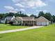 Spacious front lawn and long driveway leading to a tan home with an attached two-car garage at 110 Westlake Dr, Wendell, NC 27591