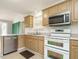 Well-lit kitchen with stainless steel appliances, wooden cabinets, and tile flooring at 110 Westlake Dr, Wendell, NC 27591