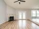 Spacious living room with a fireplace, French doors, wood floors, neutral paint, and a ceiling fan at 110 Westlake Dr, Wendell, NC 27591