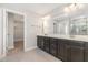 Bathroom with double vanity, large mirror, and walk-in shower with gray tile surround at 1127 Timbercut Dr, Durham, NC 27703