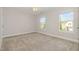 Bedroom with neutral walls, carpet, and two windows offering community views at 1127 Timbercut Dr, Durham, NC 27703