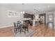Open concept view of the dining room that features wood floors, modern lighting, and a window with shutter-style shades at 1127 Timbercut Dr, Durham, NC 27703
