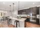Modern kitchen with dark cabinetry, granite countertops, a large island, and stainless steel appliances at 1127 Timbercut Dr, Durham, NC 27703