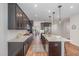 Spacious kitchen featuring dark cabinets, granite countertops, a large island, and modern appliances at 1127 Timbercut Dr, Durham, NC 27703