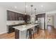 Modern kitchen with dark cabinetry, granite countertops, a large island, and stainless steel appliances at 1127 Timbercut Dr, Durham, NC 27703