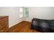 A cozy bedroom is furnished with wooden floors and bathed in natural light through the window at 117 Garden Oaks Dr, Smithfield, NC 27577