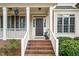 Inviting front porch with brick steps, white railings, and manicured landscaping at 117 Garden Oaks Dr, Smithfield, NC 27577