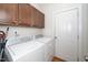 Functional laundry room with overhead cabinetry and modern white washer and dryer units at 117 Garden Oaks Dr, Smithfield, NC 27577
