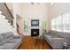 Bright living room features hardwood floors, fireplace, and staircase with iron spindles at 117 Garden Oaks Dr, Smithfield, NC 27577